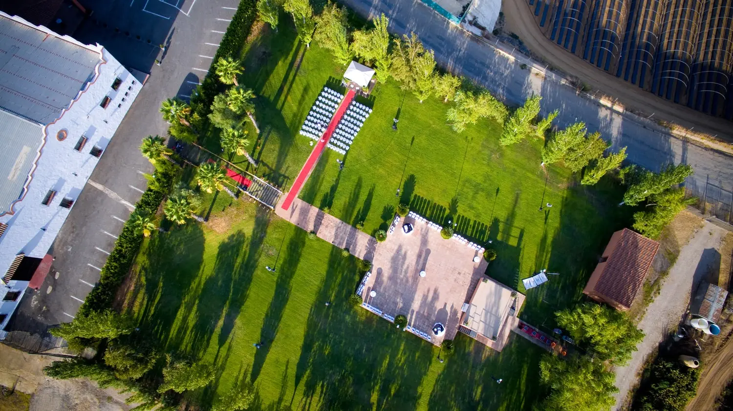 Vista cenital de la Hacienda Valdeflores: el edificio blanco a un lado, el jardín con una ceremonia montada y la zona enlosada en el centro